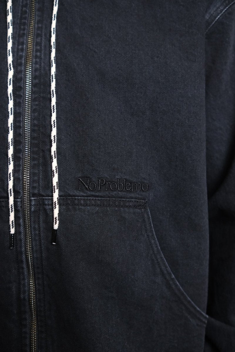 Détail de la broderie Mini Problemo sur la veste denim noire