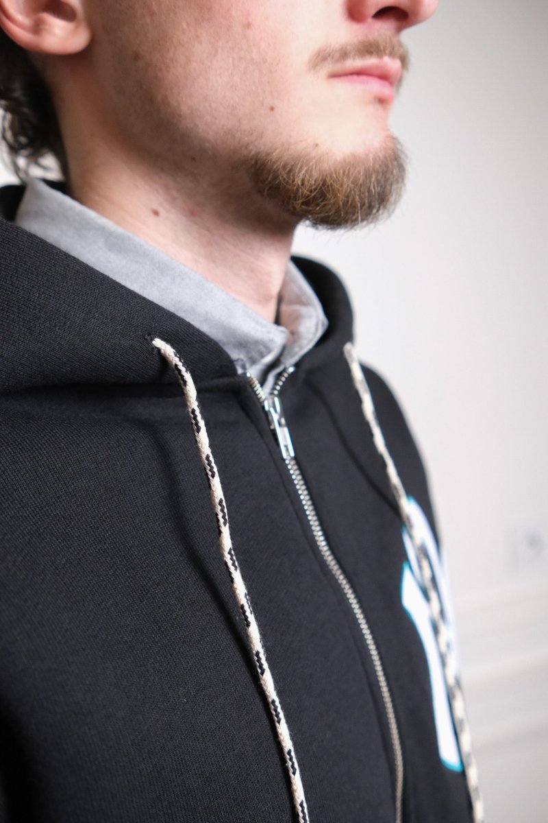Détail du branding Nyp discret sur le hoodie zippé premium No Problemo noir