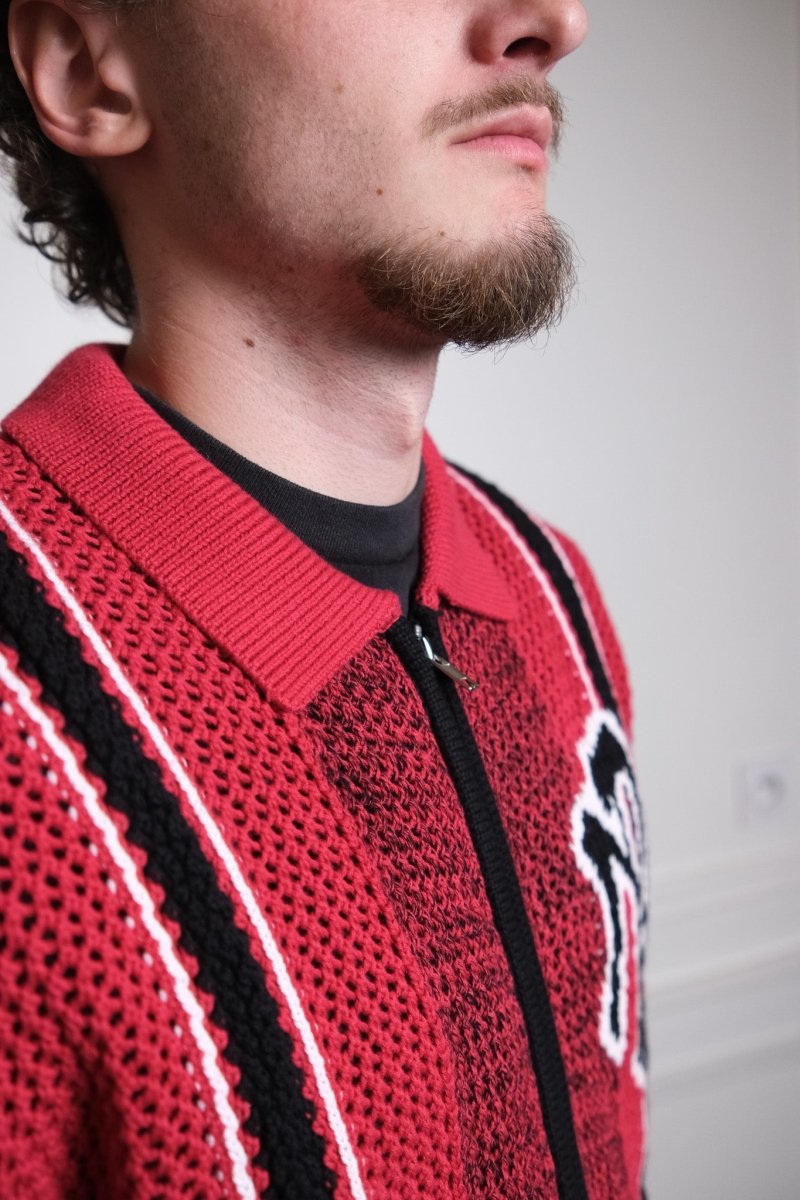 Détail du graphique bold et de l'intarsia piqué sur le devant du pull rouge