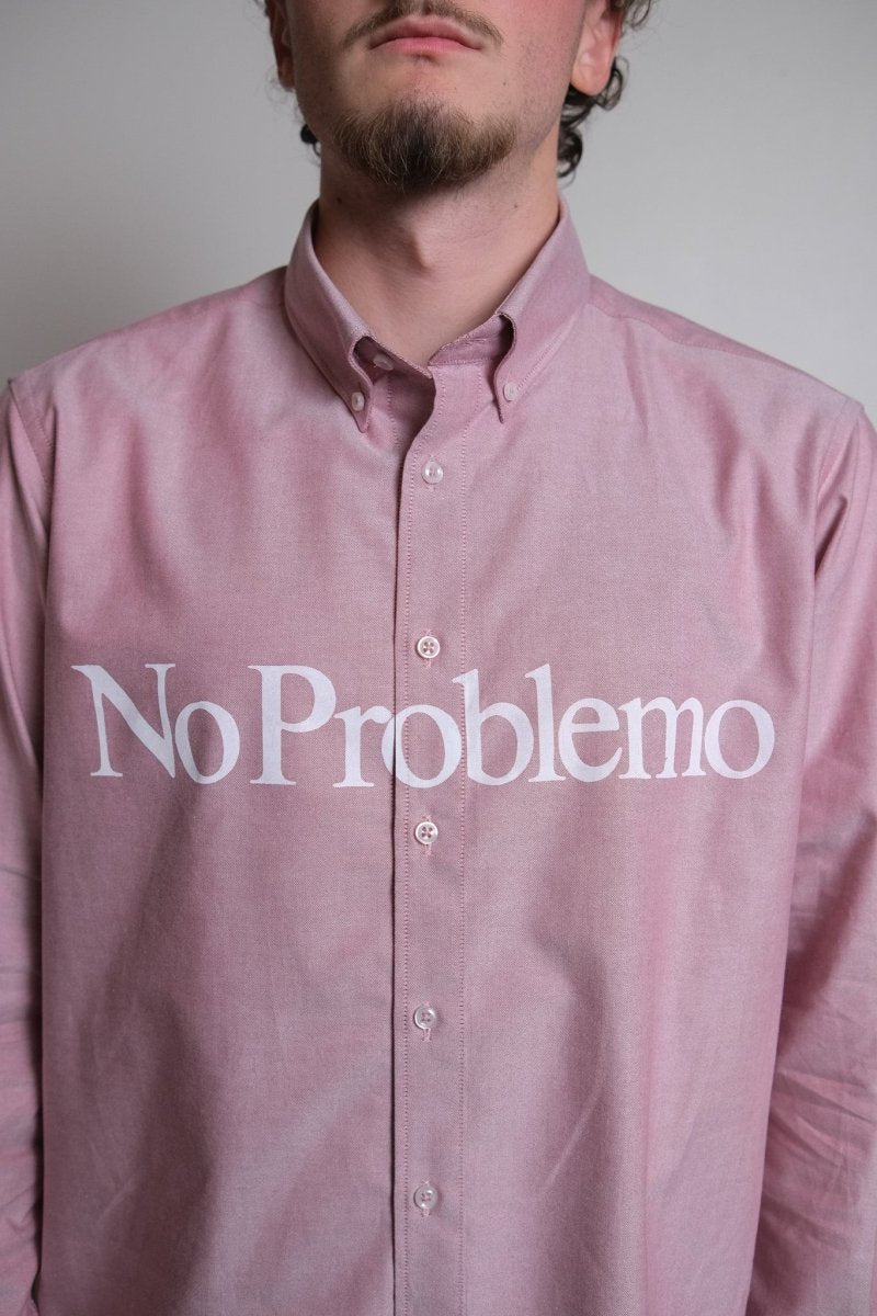 Détail du logo No Problemo imprimé sur la poitrine de la chemise rouge