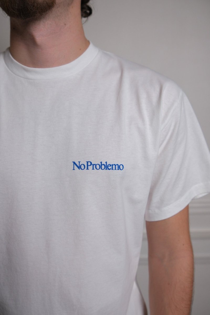 Détail du mini logo No Problemo sérigraphié sur le devant du t-shirt blanc
