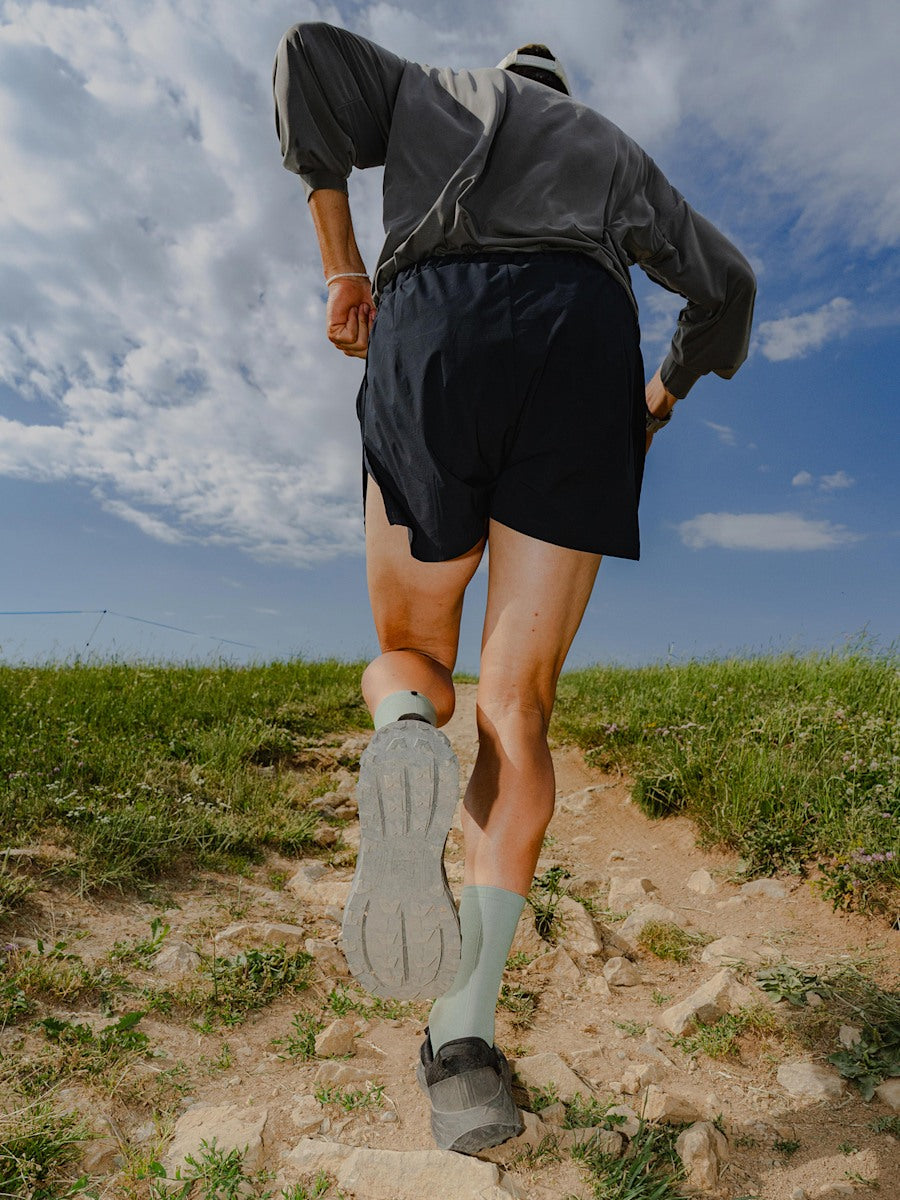 Veja Harpie Trail AeroShell Full Black, en course sur un chemin de trail
